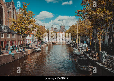 AMSTERDAM, Paesi Bassi - 09 Settembre 2018: Canal e la chiesa di San Nicola in Amsterdam, Paesi Bassi in una giornata autunnale. I turisti relax sulle rive del canale. Vacanze in Europa Foto Stock