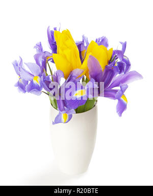 Iridi e tulipani in vaso bianco isolato su bianco. Foto Stock