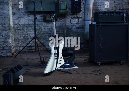 Un nero chitarra elettrica su un supporto isolato su bianco con tracciato  di ritaglio Foto stock - Alamy