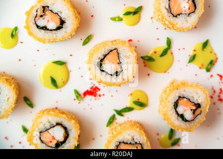 Rotoli di sushi sparsi su sfondo bianco vista superiore Foto Stock