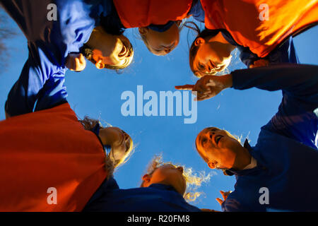 Ragazze Calcio team ascolto di pulmann in huddle Foto Stock