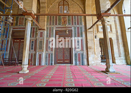 Il Cairo, Egitto - 21 dicembre 2017: incisa la porta in legno con intarsi in avorio è circondato da colorate piastrelle di pietra, Sultan Al-Muayyad moschea, nel mese di dicembre Foto Stock