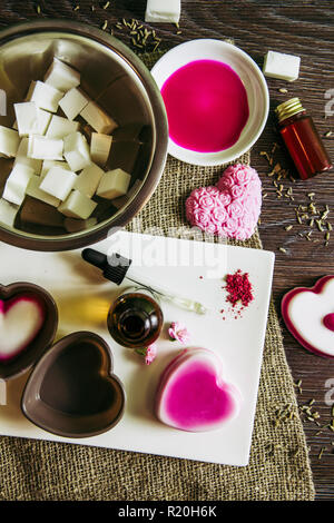 Fare sapone da versare e la fusione di sapone concetto base. Creazione di sapone ingredienti su legno marrone. sfondo fondere e versare il metodo, acquistare una base di sapone. Hobby. Foto Stock