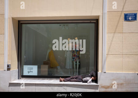 Fashion shop finestra e uomo addormentato nella parte anteriore della finestra ermou monastiraki Atene GRECIA Foto Stock
