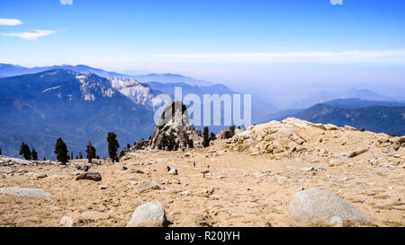 Vedute aeree del sentiero escursionistico e la valle al di là di come si vede dal picco di alta nel Parco Nazionale di Sequoia, Sierra Nevada, in California; il fumo fro Foto Stock