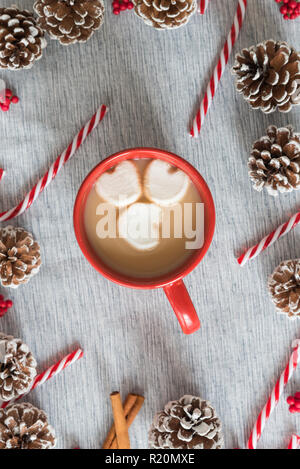 Piatto di natale-lay still life cioccolata in tazza rossa con heart-shaped marshmallows Foto Stock