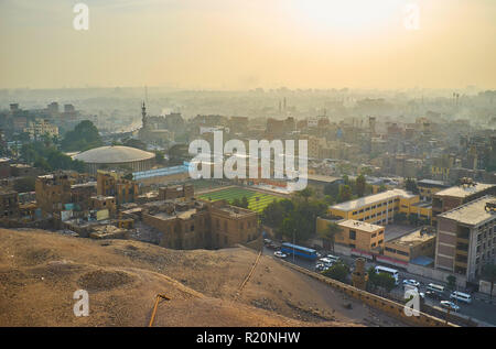 Guardare il tramonto sopra i foggy quartieri residenziali del Cairo dalla parete della cittadella di Saladino, Egitto. Foto Stock