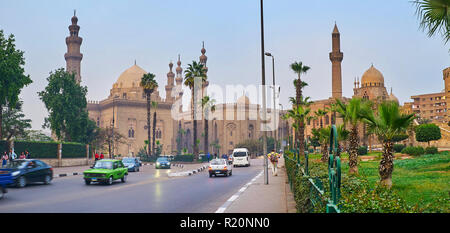 Il Cairo, Egitto - 21 dicembre 2017: la piacevole passeggiata lungo Salah El Deen Piazza con vista sul verde giardino, traffico veloce e la storica moschee di Sulta Foto Stock