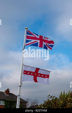 La Union Jack e la bandiera di St George volare insieme su un polo Foto Stock