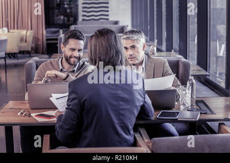 Allegro giovane uomo comunicante con il futuro partner Foto Stock