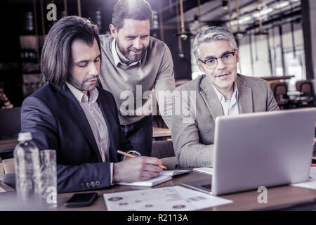 Attento brunette manager di creazione annotazioni nel libro Foto Stock