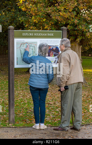 Centri di informazione turistica a Holkham park, Holkham hall nel Norfolk con un paio o il marito e la moglie di ottenere indicazioni stradali guardando una mappa. Foto Stock