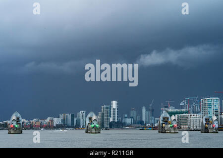 Una vista della Thames Barrier con Canary Wharf in background. Dalla città aperta architettura Tamigi Tour East. Foto Data: Sabato, 10 novembre Foto Stock