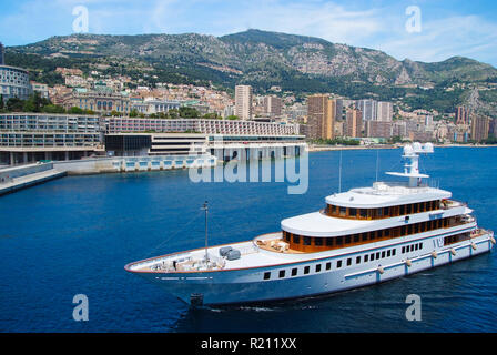 Monte Carlo, Monaco - Dicembre 08, 2009: W2 Wedge Too yacht andare lungo la costa del mare. Imbarcazioni e città sul paesaggio di montagna. Lo stile di vita di lusso. Piacere e sport. Vacanze estive e wanderlust. Foto Stock