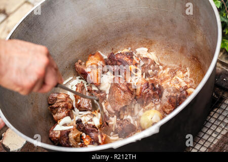 La miscelazione di bollito di agnello e verdure in un calderone. Preparazione della zuppa Chorba sul fuoco aperto, pasto tradizionale per molte cucine nazionali in Europa e Africa Foto Stock