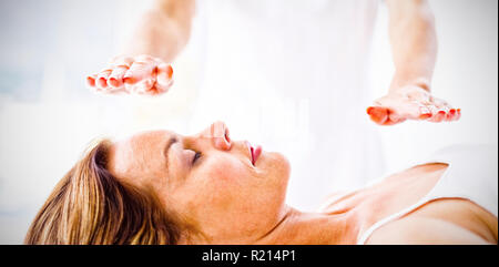 Sezione mediana del terapista esegue trattamento reiki sulla donna Foto Stock