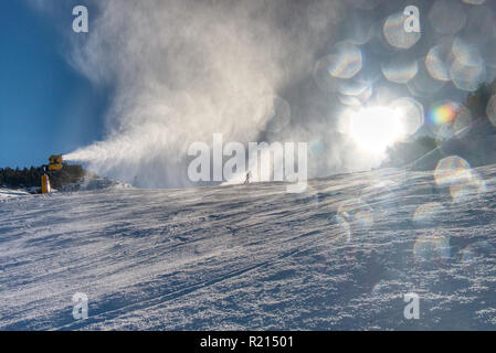 Irrorazione di innevamento artificiale neve sulle piste per sciatori in montagna Foto Stock