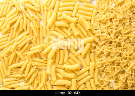 Tipi di pasta italiana penne rigatoni farfalle. Concetto di sfondo alimentare Foto Stock