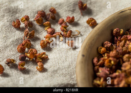 Materie organiche Szechuan secco di pepe in una ciotola Foto Stock