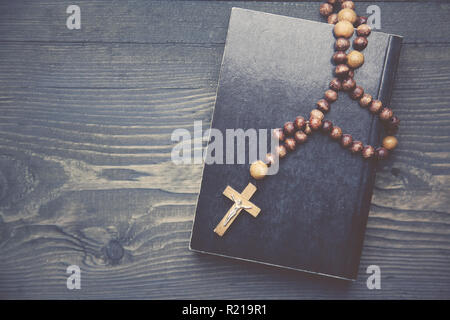 Croce sul libro sul tavolo di legno Foto Stock