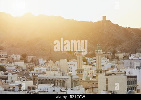 Paesaggio urbano in vista della città di Muscat al tramonto. Il capitale di Oman. Foto Stock