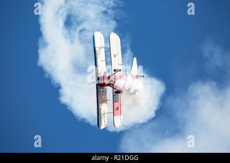 MONROE, NC (USA) - 10 Novembre 2018: un biplano acrobatico esegue un cavatappi manuver nel profondo blu del cielo al Warbirds su Monroe Air Show. Foto Stock