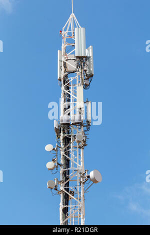 Torre di telecomunicazioni contro il cielo blu, con antenne di telefonia mobile Foto Stock