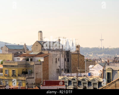 Vista sui tetti di edifici più antichi di Barcellona, in Spagna, con il Montjuïc torre delle comunicazioni in background Foto Stock