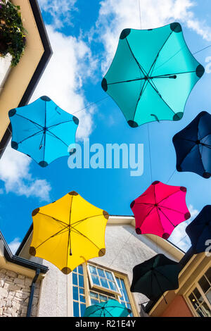 Un display di ombrelloni colorati al di sopra di un outdoor shopping mall a Kendal, Cumbria, nel distretto del lago, REGNO UNITO Foto Stock