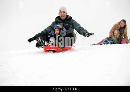 Padre e figlio slittano in Shropshire Winter scena Gran Bretagna Regno Unito Famiglie che slittano su Ironbridge 2017 persone bambini neve Foto Stock