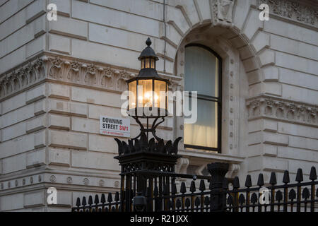 Come primo ministro Theresa Maggio negozia Brexit problemi e i membri del suo governo conservatore continua a dimettersi in risposta alla sua presentazione dei termini correnti, alla luce su di Downing Street di sicurezza rinforzato le ringhiere splende sulle pareti di Whitehall, il 15 novembre 2018, a Londra, in Inghilterra. Foto Stock