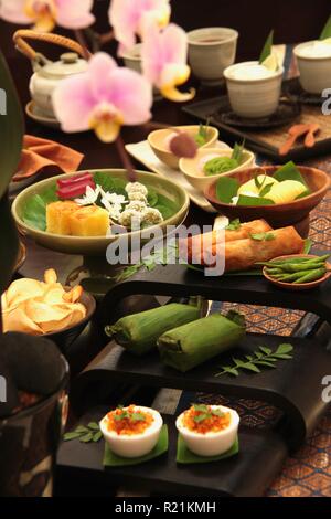 Indonesiano tè pomeridiano per due. Un tè pomeridiano che serve cucina Indonesiana salati e dolci. Foto Stock