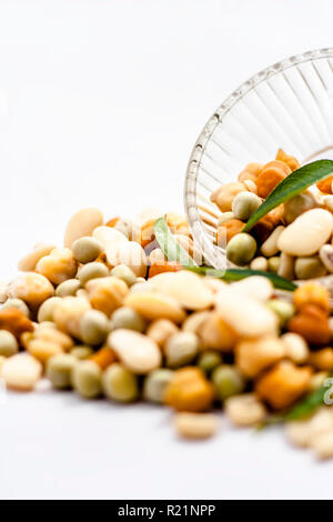 Materie organici essiccati misti freschi impulsi o grani misti in una ciotola di vetro isolato su bianco. Foto Stock