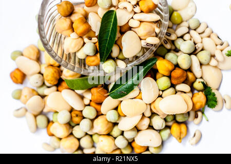 Materie organici essiccati misti freschi impulsi o grani misti in una ciotola di vetro isolato su bianco. Foto Stock