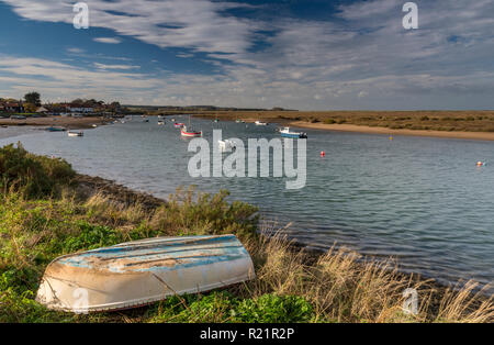 Burnham Overy Staithe sul cpast di Norfolk su una luminosa giornata autunnale con barche ormeggiate sul tidal creek. Foto Stock