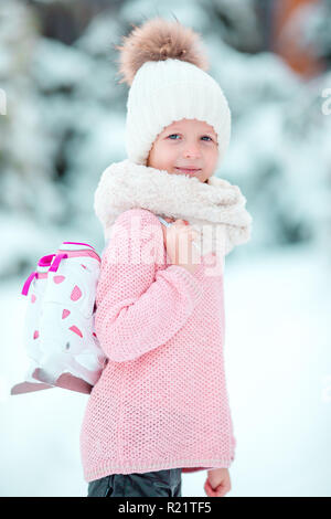 Carino capretto piccolo ragazza sta andando pattino all'esterno. Foto Stock