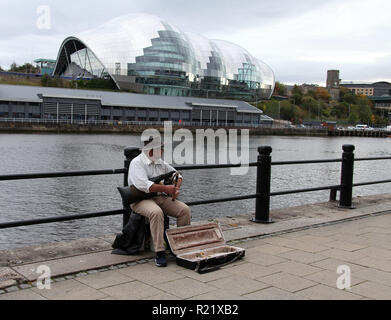 Busker giocando Northumbrian tubi di piccole dimensioni sulla banchina a Newcastle upon Tyne Foto Stock