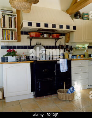 Splashback piastrellate di nero sopra Aga in cucina di paese Foto Stock