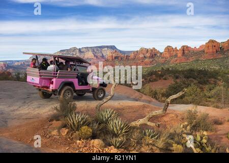 Jeep rosa fuori strada terreno High Clearance Sports Utility veicolo con turisti. Broken Arrow Slick Rock Tour e canyon vista paesaggio Sedona, Arizona Foto Stock