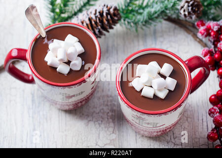 Cioccolata calda con marshmallows in tazze di Natale su bianco incrinato sfondo di legno. Close up. Foto Stock