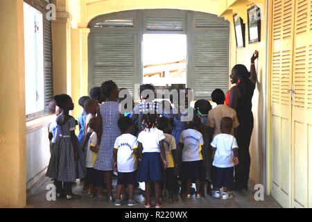 I bambini a scuola Group Les patrocini imparare circa il colonialismo e la schiavitù di Grand Bassam, Costa d'Avorio Foto Stock
