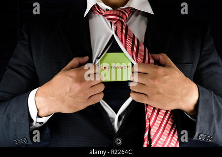 Nascondere la depressione. Un uomo in tuta e cravatta rossa e apertura unbuttoning la sua camicia interna per rivelare la sua depressione scritto su un greeen nota adesiva. Foto Stock