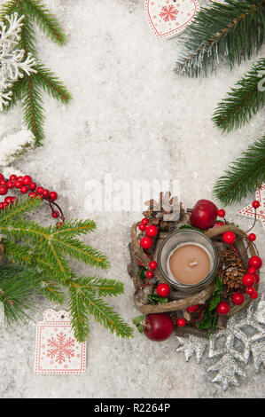 Anno nuovo sfondo con neve artificiale, una candela e Natale-rami di alberi Foto Stock