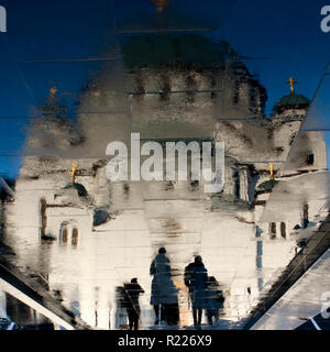 Sfocata la riflessione di San Sava tempio ortodosso e alcune persone si avvicina, sul bagnato pavimentazione della città di Belgrado, Serbia Foto Stock