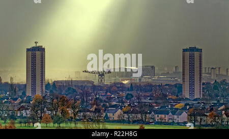 Glasgow, Scotland, Regno Unito, 16 novembre 2018. Regno Unito Meteo Meteo un avviso di tempesta in anticipo con una giornata noiosa come raggi crepuscolari noto come raggi di Dio appaiono su knightswood campo da golf, il sud di Glasgow, pietre miliari locali come le torri Scotstoun, Queen Elizabeth University Hospital e il Titan Crane, l'ultimo residuo della cantieristica locale sul fiume Clyde. Credito: gerard ferry/Alamy Live News Foto Stock
