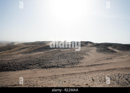 Auto superare le dune di sabbia di ostacoli. Concorrenza racing sfida deserto. Unità auto offroad con nuvole di polvere. Veicolo Offroad racing ostacoli nel deserto. Deserto interminabile. Gara di deserto di sabbia. Foto Stock