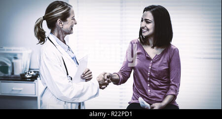 Medico donna stringono le mani con paziente Foto Stock