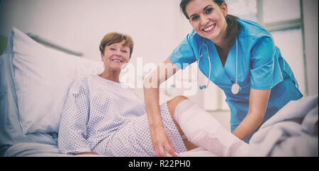 Un infermiere del bendaggio gamba del paziente Foto Stock