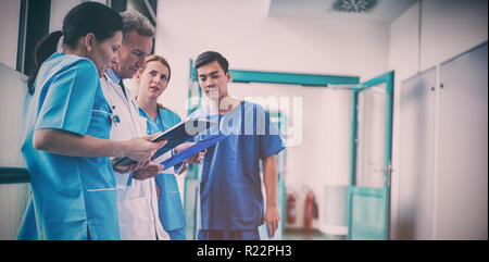 Medico e chirurghi e discutendo con la relazione nel corridoio Foto Stock