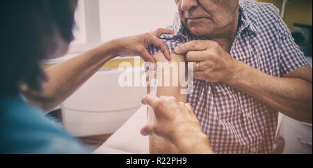 Medico donna dando una iniezione di un paziente Foto Stock